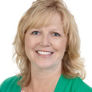 Headshot of Susan Kubert with.shoulder length blonde hair and a bright green blouse.